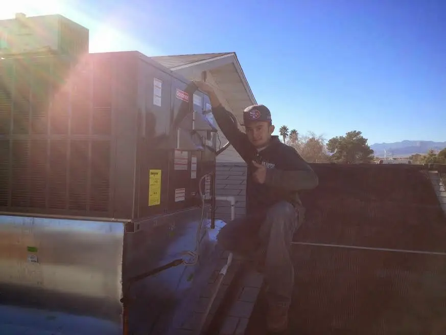 HVAC technician performing HVAC Inspection on a rooftop unit in Payson